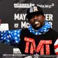 Petinju AS, Floyd Mayweather Jr, memamerkan cek bernilai 100 juta dolar pada konferensi pers menjelang duel kontra Conor McGregor di Staples Center, Selasa (11/7/2017) malam waktu setempat. (AFP/Gene Blevins)