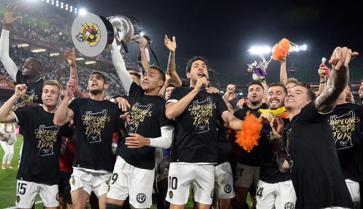 Para pemain Valencia merayakan keberhasilan menjuarai Copa Del Rey 2018/2019 setelah mengalahkan Barcelona dalam laga final di Benito Villamarin Stadium, Sevilla (25/5/2019). Dari total 224 laga di semua ajang, Barcelona tercatat kalah sebanyak 59 kali dari Valencia dan menang dalam 109 laga. (AFP/Lluis Gene)