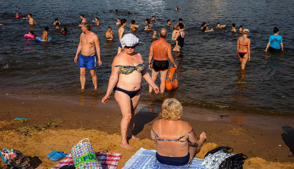 Orang-orang berjemur dan mendinginkan diri di Sungai Moskva pada musim panas di Moskow, Rusia, Selasa (13/7/2021). Moskow dilanda gelombang panas bersejarah pada akhir Juni, dengan suhu mencapai rekor 120 tahun. (DIMITAR DILKOFF/AFP)