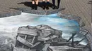 Sejumlah siswa berpose di depan karya ilusi optik bergambar kota Aleppo yang hancur akibat perang di kampus Universitas Meiji di Tokyo, Jepang (18/11). Karya ini mendorong agar para siswa ikut prihatin terkait perang di Suriah. (AFP/Toshifumi Kitamura)