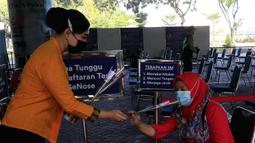 Petugas PT KAI Daop 1 Jakarta membagikan bunga kepada penumpang di Stasiun Gambir, Rabu (21/4/2021). PT KAI DAOP 1 memperingati Hari Kartini menginspirasi para penumpang agar semangat berjuang melawan pandemi COVID-19 dengan selalu menerapkan protokol kesehatan. (Liputan6.com/Herman Zakharia)