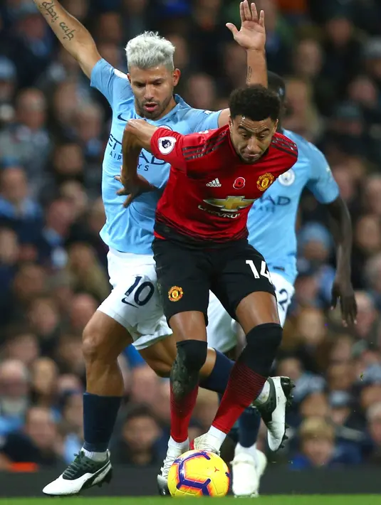 Striker Manchester City, Sergio Aguero berusaha merebut bola yang dibawa striker MU, Jesse Lingard saat bertanding pada lanjutan Liga Inggrid di stadion Etihad, Manchester (11/11). City menang 3-1 atas MU. (AP Photo/Dave Thompson)