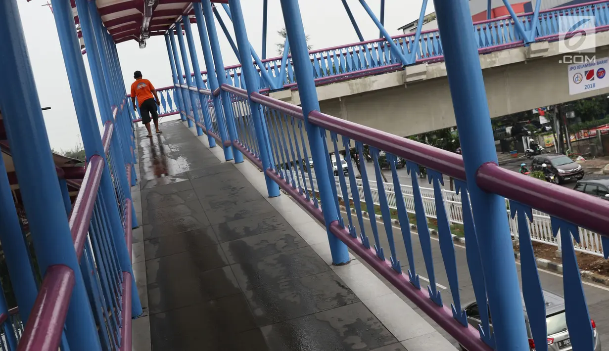 Warga melintas di JPO Jelambar Barat di Jalan Pangeran Tubagus Angke, Jakarta, Sabtu (22/12). Pagar pembatas JPO Jelambar Barat juga dihias dengan ornamen gigi balang khas budaya Betawi. (Liputan6.com/Helmi Fithriansyah)