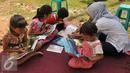 Sejumlah anak membaca buku di halaman Rusun Cipinang Besar Selatan, Jakarta, Rabu (27/4). Pemprov DKI Jakarta melengkapi fasilitas rusun tersebut berupa perpustakaan dan taman bermain anak. (Liputan6.com/Gempur M Surya)