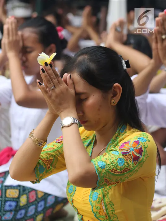 Sejumlah umat Hindu berdoa saat upacara Tawur Kesanga di Pura Aditya Jaya, Rawamangun, Jakarta, Jumat (16/3). Upacara Tawur Kesanga diadakan dengan tujuan memohon pada Tuhan Yang Maha Esa untuk kedamaian alam dan lingkungan. (Liputan6.com/Arya Manggala)