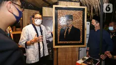 Menteri Parekraf Sandiaga Uno melihat salah satu karya pada acara Apresiasi Kreasi Indonesia (AKI) 2021 di Gandaria City, Jakarta, Kamis (9/12/2021). AKI 2021 yang telah berjalan di 16 kota dengan mengangkat tema ‘Produk Indonesia untuk Ekonomi Kuat’. (Liputan6.com/Fery Pradolo)