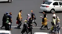 Warga Iran yang mengenakan masker menyeberang jalan di ibu kota Teheran, Sabtu (3/7/2021). Presiden Hassan Rouhani mengaku khawatir Iran akan dilanda gelombang kelima pandemi Covid-19 karena kemunculan virus corona varian Delta. (ATTA KENARE/AFP)