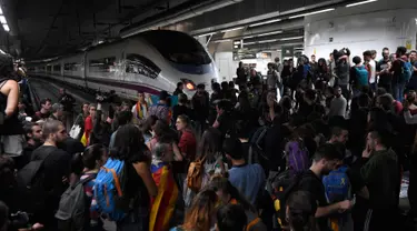 Ratusan massa pro-kemerdekaan Catalonia saat memblokir rel kereta api di Stasiun Sants di Barcelona (8/11). Pengunjuk rasa memblokir jalan dan jalur kereta api setelah para pemimpin separatis ditahan di Madrid. (AFP Photo/Lluis Gene)