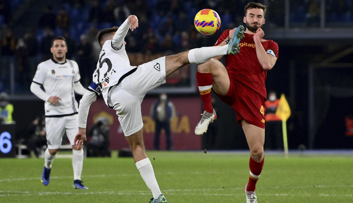Bek AS Roma Chris Smalling berebut bola dengan bek Spezia, Martin Erlic pada pekan ke-17 Liga Italia 2021/2022 di Olimpico, Selasa (14/12/2021) dini hari WIB. AS Roma berhasil mendulang tiga poin setelah mengalahkan Spezia dengan skor 2-0. (Alfredo Falcone/LaPresse via AP)