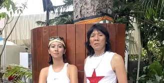 Reny dan Bimbim bergaya ala bohemian. Tampilan ini terlihat begitu seru dan vibrant dengan warna kontras. Reny menambah headband untuk melengkapi gayanya. [Foto: Instagram/ Realmemi]