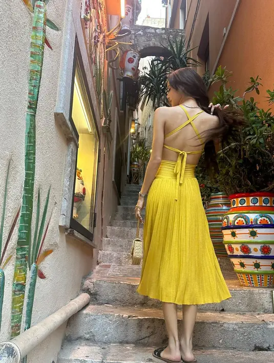 Puas melihat pemandangan, Lisa kemudian berjalan santai di kota mengenakan cut-out dress berwarna kuning cerah dari Zimmerman. [Instagram/lalalalisa_m]