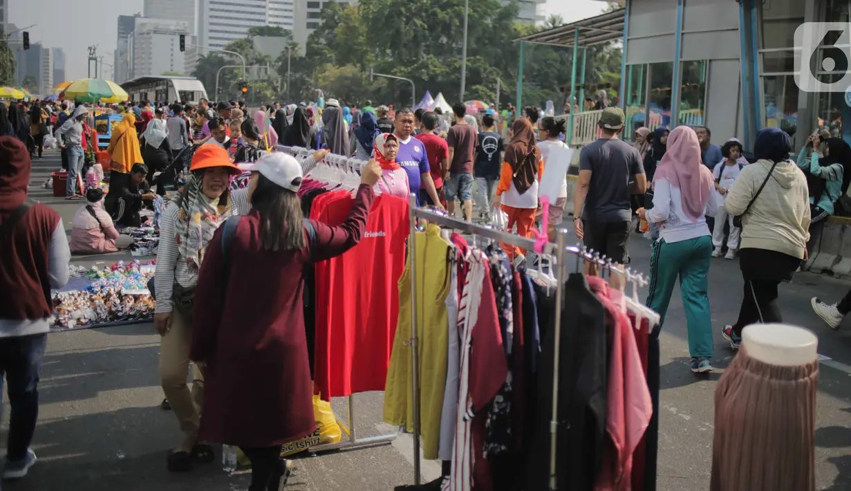Pedagang kaki lima (PKL) berjualan di jalan saat car free day (CFD) di kawasan Bundaran HI, Jakarta, Minggu (6/10/2019). Kurangnya pengawasan petugas menyebabkan banyak PKL yang berjualan tidak pada tempat yang telah disediakan oleh Pemprov DKI Jakarta. (Liputan6.com/Faizal Fanani)