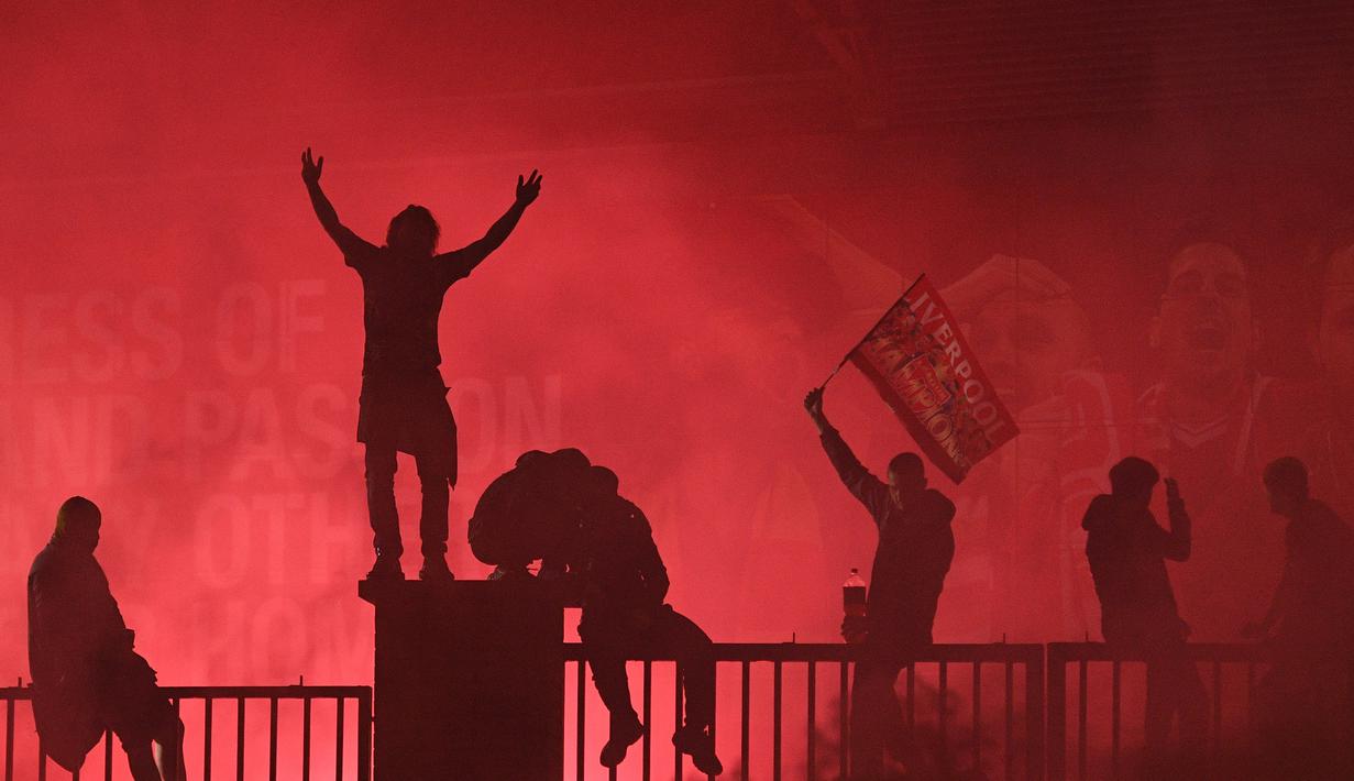 Fans Liverpool merayakan gelar juara Premier League di area Standion Anfield usai pertandingan Liverpool melawan Chelsea, Kamis (23/7/2020) dini hari WIB. Fans Liverpool tetap berdatangan ke area Stadion Anfield meski ada permintaan untuk merayakan di rumah. (AFP/Oli Scarff)
