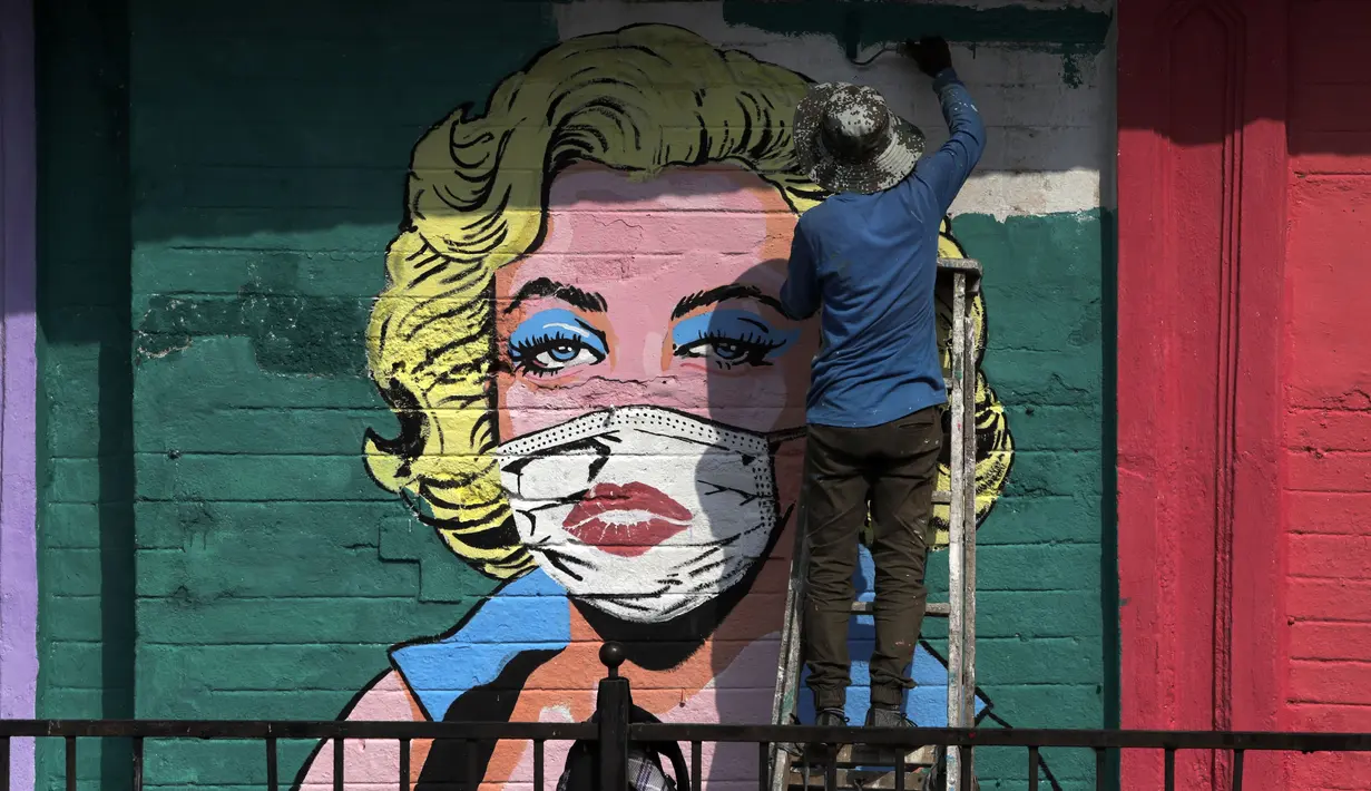 Seniman melukis mural untuk menyebarkan kesadaran akan pencegahan virus corona di Mumbai, India (26/3/2021). Kementerian Kesehatan melaporkan 43.846 kasus baru dalam 24 jam terakhir, peningkatan satu hari terburuk sejak pertengahan November. (AP Photo/Rajanish Kakade)