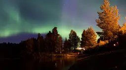 Pancaran cahaya aurora borealis menghiasi Desa Erikslund di Vasternorrland County, Swedia (23/8). Fenomena alam yang indah ini terjadi pada bulan Maret-April dan September-Oktober. (AFP PHOTO/ JONATHAN NACKSTRAND)