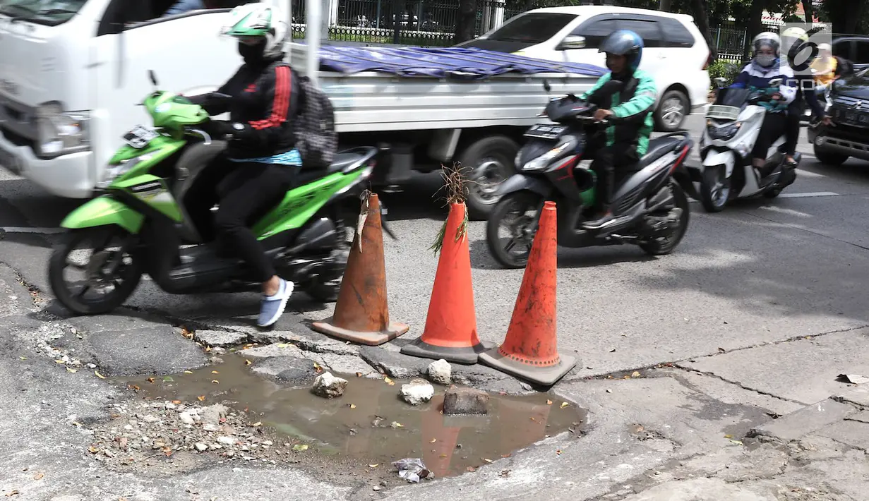 Pengendara menghindari jalan berlubang di kawasan Tanjung Barat, Jakarta, Rabu (30/1). Kondisi jalan rusak tersebut telah beberapa kali menyebabkan kecelakaan sehingga butuh penanganan. (Liputan6.com/Immanuel Antonius)