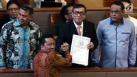 Ketua Baleg DPR Supratman Andi Agtas berjabat tangan dengan Menkumham Yasonna Laoly dalam sidang paripurna ke-9 Masa Persidangan I 2019-2020 di Kompleks Parlemen, Senayan, Selasa (17/9/2019). Rapat Paripurna DPR menyetujui Revisi Undang-Undang Nomor 30 Tahun 2002 tentang KPK. (Liputan6.com/Johan Tal