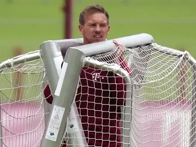 Pelatih baru Bayern Munchen, Julian Nagelsmann membawa tiang gawang sebelum sesi latihan pertama bersama timnya di tempat latihan di Munich, Jerman selatan (7/7/2021). Bayern Munchen menyongsong musim ini dengan pelatih baru yaitu Julian Nagelsmann. (AP Photo/Matthias Schrader)