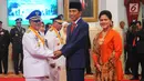 Presiden Joko Widodo (tengah) didampingi Ibu Negara Iriana (kanan) menyalami Gubernur Maluku Utara Abdul Gani Kasuba saat pelantikan di Istana Negara, Jakarta, Jumat (10/5/2019). Abdul Gani dan Al Yasin merupakan pasangan Gubernur dan Wagub hasil Pilkada Serentak 2018. (Liputan6.com/Angga Yuniar)