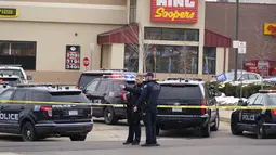 Polisi berjaga di tempat kejadian di luar toko kelontong King Soopers tempat penembakan terjadi di Boulder, Colorado (22/3/2021). Aksi penembakan tersebut rupanya menargetkan antrean vaksinasi yang tengah dilakukan di pusat perbelanjaan tersebut. (AP Photo/Joe Mahoney)