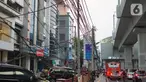Instalasi kabel menjuntai di Jalan Panglima Polim, Kebayoran Baru, Jakarta, Kamis (31/10/2019). Buruknya pemasangan instalasi kabel di Ibukota menyebabkan banyak kabel yang menjuntai hingga mengganggu ketertiban umum. (Liputan6.com/Immanuel Antonius)