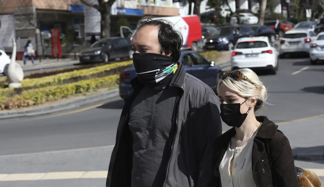 Orang-orang yang memakai masker untuk membantu melindungi dari penyebaran corona, berjalan sebelum penguncian nasional, di Ankara, Rabu (21/4/2021). Turki terus mencatat rekor kematian harian COVID-19 tertinggi pada hari Rabu, dengan 362 kematian terdaftar dalam 24 jam terakhir. (AP/Burhan Ozbilici)