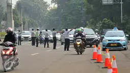 Petugas mengatur lalu lintas pada saat uji emisi di pintu satu Gelora Bung Karno, Jakarta, Selasa (17/5). Pemkot Administrasi Jakpus melakukan uji emisi kendaraan selama tiga hari untuk mengevaluasi kualitas udara perkotaan. (Liputan6.com/Gempur M Surya)