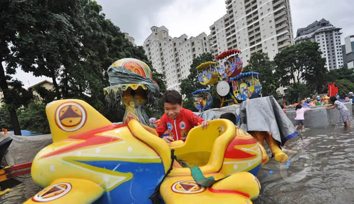 Tingginya curah hujan di wilayah Jakarta mengakibatkan sejumlah fasilitas umum ikut terendam banjir, Jakarta, Selasa (10/2). Tampak sejumlah anak bermain di lahan bermain Kemayoran yang terendam banjir. (Liputan6.com/Faizal Fanani)