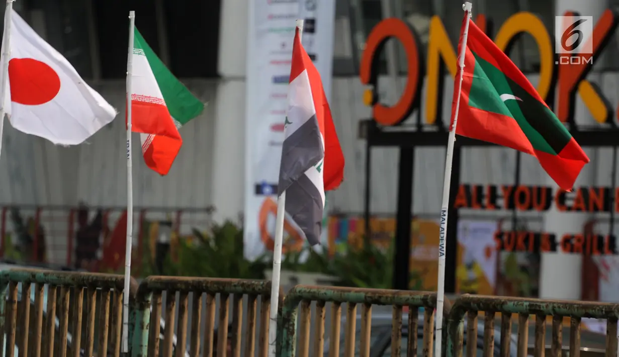 Deretan bendera negara-negara kontestan Asian Games 2018 yang terpasang menggunakan bambu di pagar pembatas Jalan Pluit Selatan Raya, Jakarta, Kamis (19/7). Bendera-bendera itu diikat di sebatang bambu yang dicat putih. (Liputan6.com/Arya Manggala)