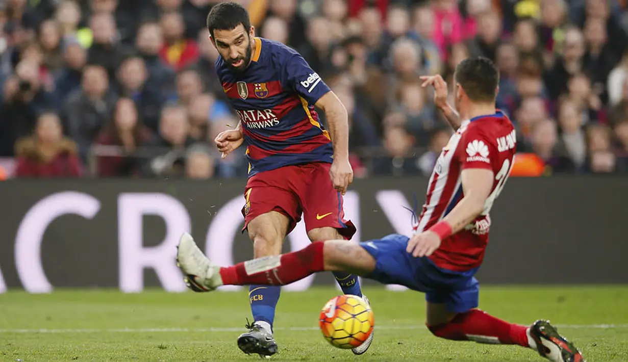 Gelandang Barccelona, Arda Turan, berusaha melewati bek Atletico Madrid, Jose Gimenez. Ini merupakan kali pertama bagi Turan menghadapi mantan klub yang dibelanya pada musim lalu. (Reuters/Albert Gea) 