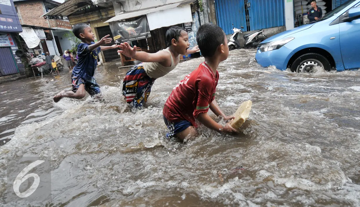 Sejumlah anak bermain banjir di kawasan Kemang Utara, Jakarta Selatan, Rabu (20/7). Banjir yang menggenangi sejumlah kawasan di Jakarta dijadikan kolam renang gratis bagi sejumlah anak. (Liputan6.com/Yoppy Renato)