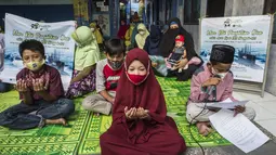 Siswa dan guru berdoa untuk 53 awak kapal selam KRI Nanggala 402 yang hilang di perairan Bali, di sebuah sekolah Islam di Surabaya, Jumat (24/4/2021). Kapal selam KRI Nanggala-402 yang membawa 53 awak dilaporkan hilang kontak di perairan Bali, Rabu, 21 April kemarin. (Juni Kriswanto/AFP)