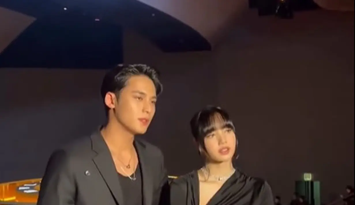 Lisa BLACKPINK dan Mingyu terlihat bercengkerama akrab saat acara dimulai. Keduanya tampil kompak dengan busana serba hitam polos. [@9yuldaengie]