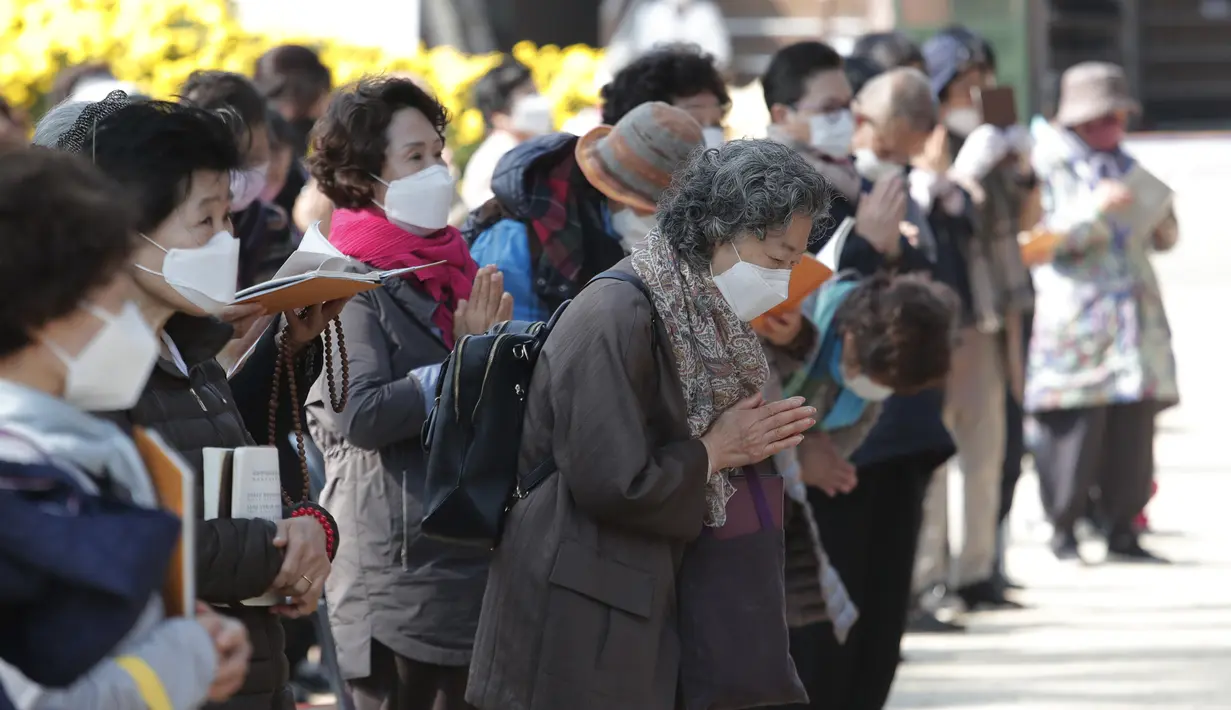 Orang-orang memakai masker untuk mencega virus corona berdoa selama kebaktian di kuil Chogyesa di Seoul, Korea Selatan, Senin (19/10/2020). Korsel pada Senin mulai menguji puluhan ribu karyawan rumah sakit dan panti jompo untuk mencegah wabah COVID-19. (AP Photo/Ahn Young-joon)