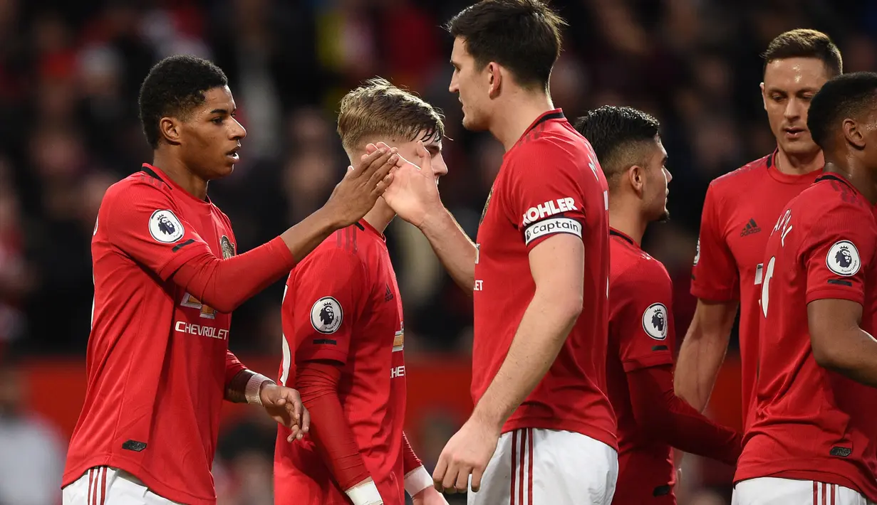 Striker Manchester United, Marcus Rashford (kiri) berselebrasi dengan rekan-rekannya usai mencetak gol ke gawang Norwich City pada pertandingan lanjutan Liga Inggris di Old Trafford (11/1/2020). Rashford mencetak dua gol dan mangantar MU menang telak 4-0 atas Norwich. (AFP/Oli Scarff)