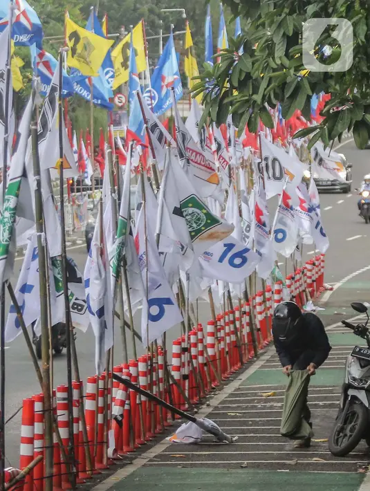 Keindahan kota menjadi terganggu dengan tampilan deretan bendera partai politik di median jalan raya itu. (Liputan6.com/Angga Yuniar)
