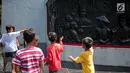 Sejumlah anak melihat relief di Monumen Pancasila Sakti, Lubang Buaya, Jakarta, Minggu (1/10). Bertepatan dengan peringatan hari Kesaktian Pancasila, sejumlah pelajar mengadakan napak tilas ke monumen Kesaktian Pancasila. (Liputan6.com/Faizal Fanani)