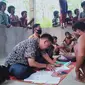 Dua orang petugas PT Pos Indonesia saat memproses pencarian bantuan sosial tunai (BST) untuk kelompok orang rimba Jambi di Dusun 24, Kabupaten Batanghari, Jambi, Jumat (17/7/2020). Bantuan tersebut untuk masyarakat kurang mampu terdampak Covid-19. (Liputan6.com/Gresi Plasmanto)