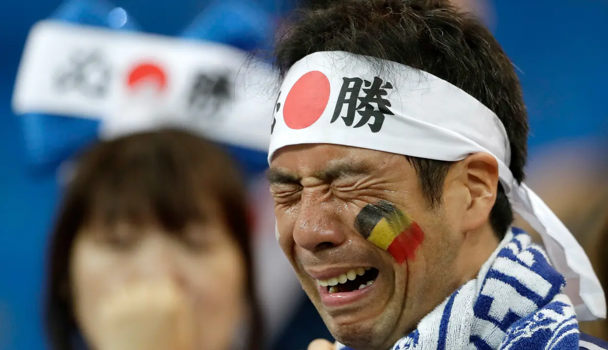 Suporter Jepang menangis usai pertandingan melawan Belgia pada babak 16 besar Piala Dunia 2018 di Rostov Arena, di Rostov-on-Don, Rusia, (2/7). Jepang takluk dengan dramatis atas Rusia 3-2. (AP Photo / Petr David Josek)