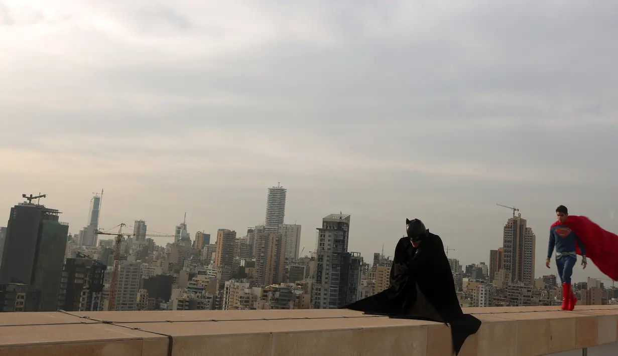 Dua orang pria mengenakan kostum Batman dan Superman saat sesi pemotretan di Lebanon (23/3). Fenomena Batman vs Superman menjadi perhatian para pecinta superhero karena film terbarunya yang muncul. (PATRICK BAZ / AFP)