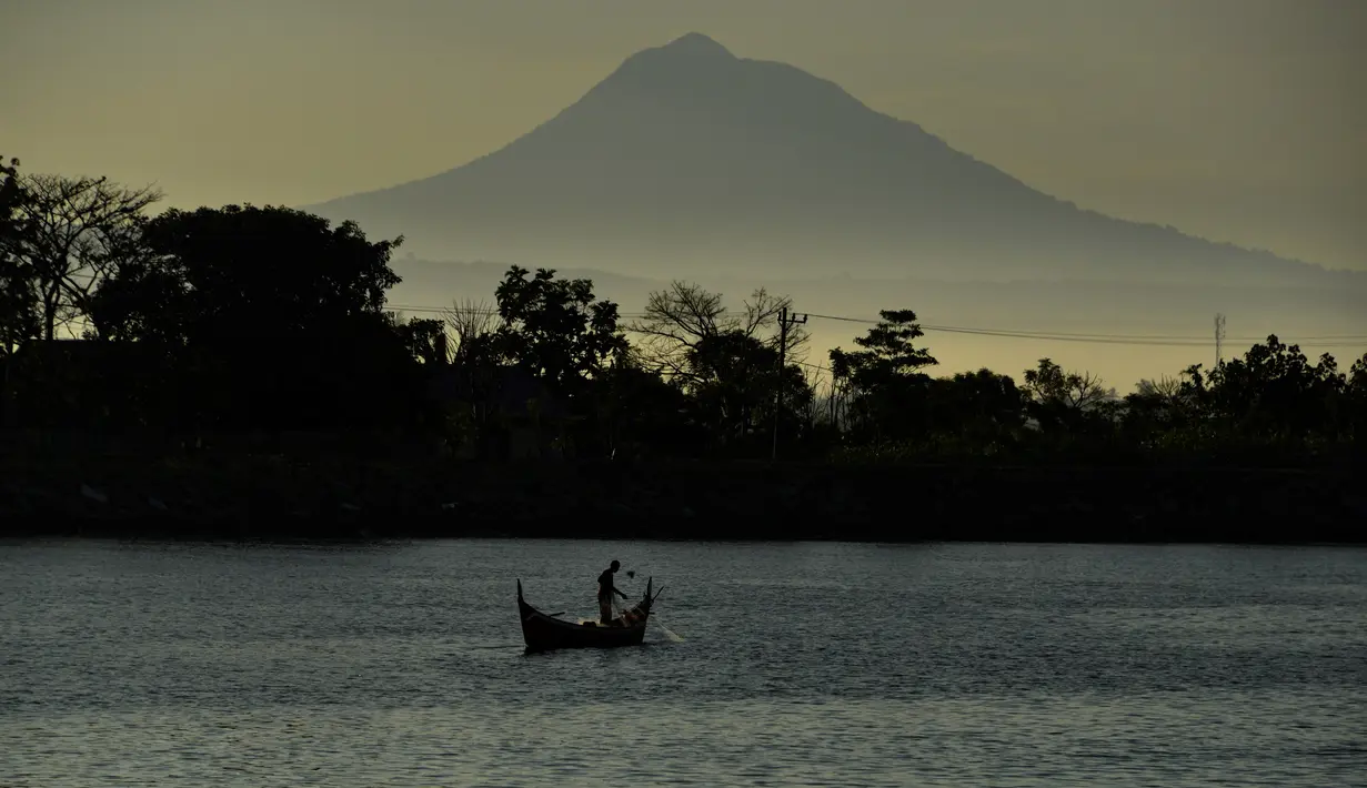 Seorang nelayan menarik jala saat memancing saat matahari terbit pada Hari Bumi di lepas pantai Banda Aceh (22/4/2021).  Hari Bumi dirancang untuk meningkatkan kesadaran dan apresiasi terhadap planet yang ditinggali manusia ini yaitu bumi. (AFP/Chaideer Mahyuddin)