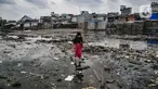 Seorang anak melintasi genangan sampah di permukiman kumuh Muara Baru, Jakarta, Rabu (19/1/2022). Badan Pusat Statistik (BPS) mencatat angka kemiskinan Indonesia turun menjadi 26,5 juta orang per September 2021 dari sebelumnya mencapai 27,54 juta orang pada Maret 2021. (merdeka.com/Iqbal S Nugroho)