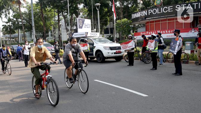 Pengguna sepeda melintas saat aran Virus corona di Bundaran HI, Jakarta, Minggu (13/9/2020). Kegiatan itu untuk mengajak warga agar disiplin mengenakan masker dan menerapkan protokol kesehatan untuk menekan penyebaran COVID-19. (merdeka.com/Arie Basuki)