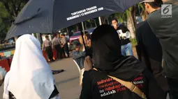 Aktivis yang tergabung dalam Jaringan Solidaritas Korban untuk Keadilan saat aksi Kamisan di depan Istana Negara, Jakarta, Kamis (25/7/2019). Aksi Kamisan ke-594 mengangkat tema '23 Tahun Tragedi 27 Juli Saat Jadi Penguasa Kok Malah Tidak Peduli?'. (Liputan6.com/Helmi Fithriansyah)