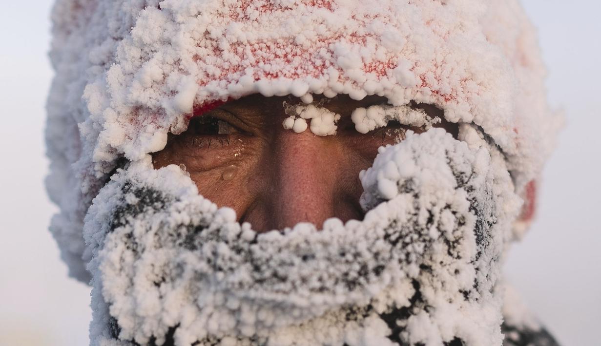 Seorang pelari berpose di depan fotografer usai menyelesaikan maraton terdingin di dunia internasional pada suhu minus 53 derajat (-63,4 Fahrenheit) di dekat Oymyakon, republik Sakha, juga dikenal sebagai Yakutia, Timur Jauh Rusia, Sabtu, 22 Januari 2022. (AP/Ivan Nikiforov)