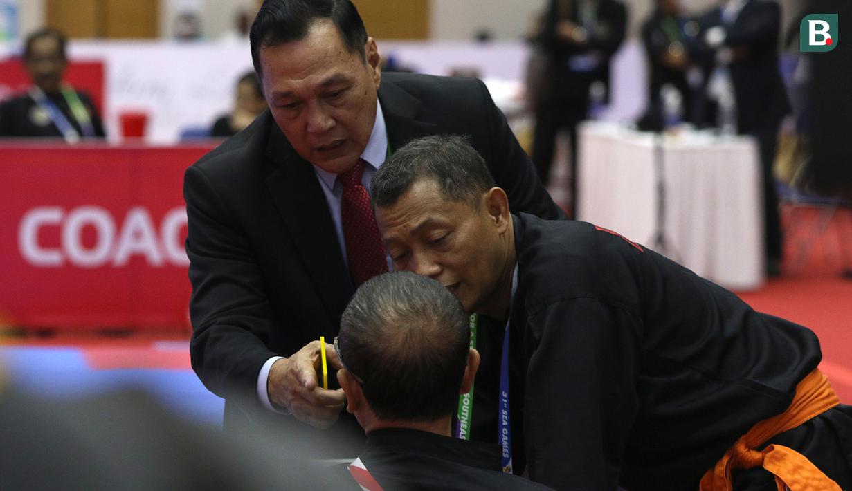 Tak selang berapa lama Benny pun menghampiri area pelatih dari tim Indonesia sambil memegang kartu berwarna kuning dan terlibat argumentasi yang meminta Bondan segera angkat kaki dari venue silat SEA Games 2021. (Bola.com/Ikhwan Yanuar)