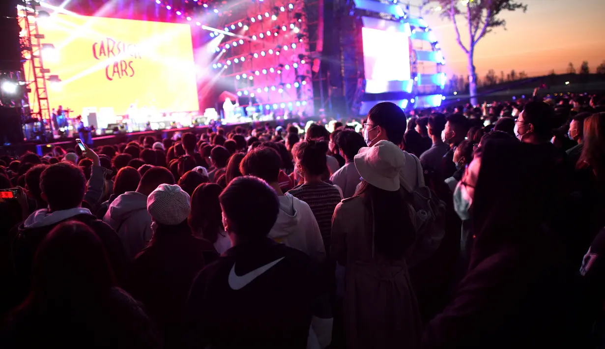 Orang-orang yang memakai masker menyaksikan penampilan sebuah band pada Festival Musik Rye yang digelar selama dua hari di Beijing pada 18 Oktober 2020. (Photo by Noel Celis / AFP)