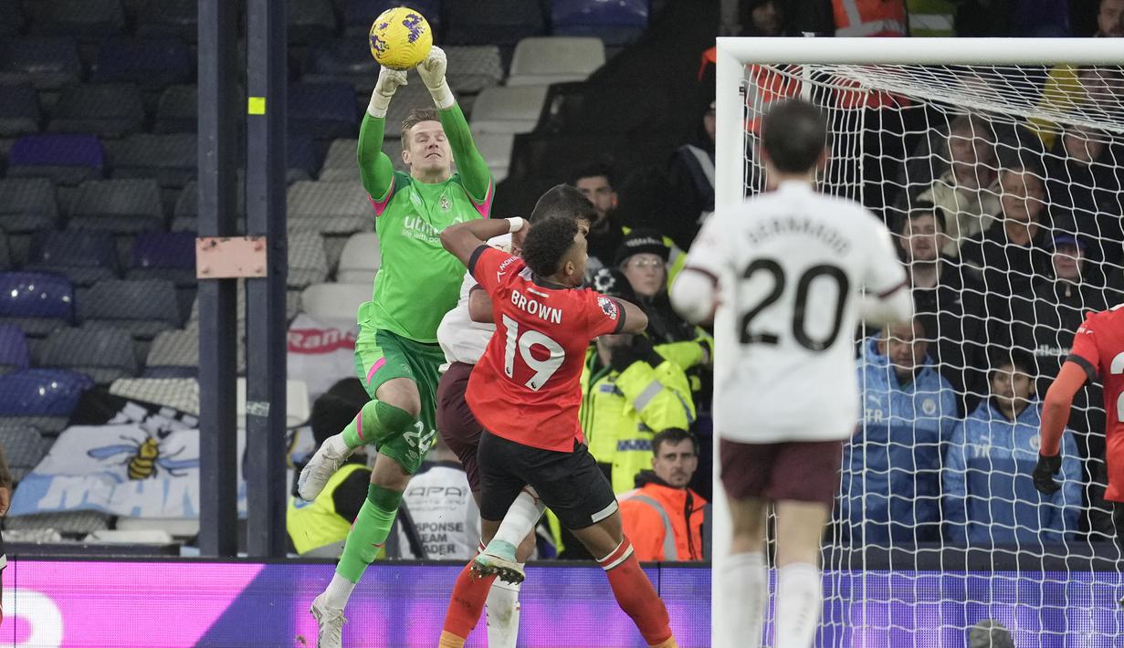 Kiper Luton Town, Thomas Kaminski berhasil menangkap bola dari ancaman pemain Manchester City pada laga pekan ke-16 Liga Inggris 2023/2024 di Kenilworth Road, Luton, Minggu (10/12/2023) malam WIB. (AP Photo/Kin Cheung)