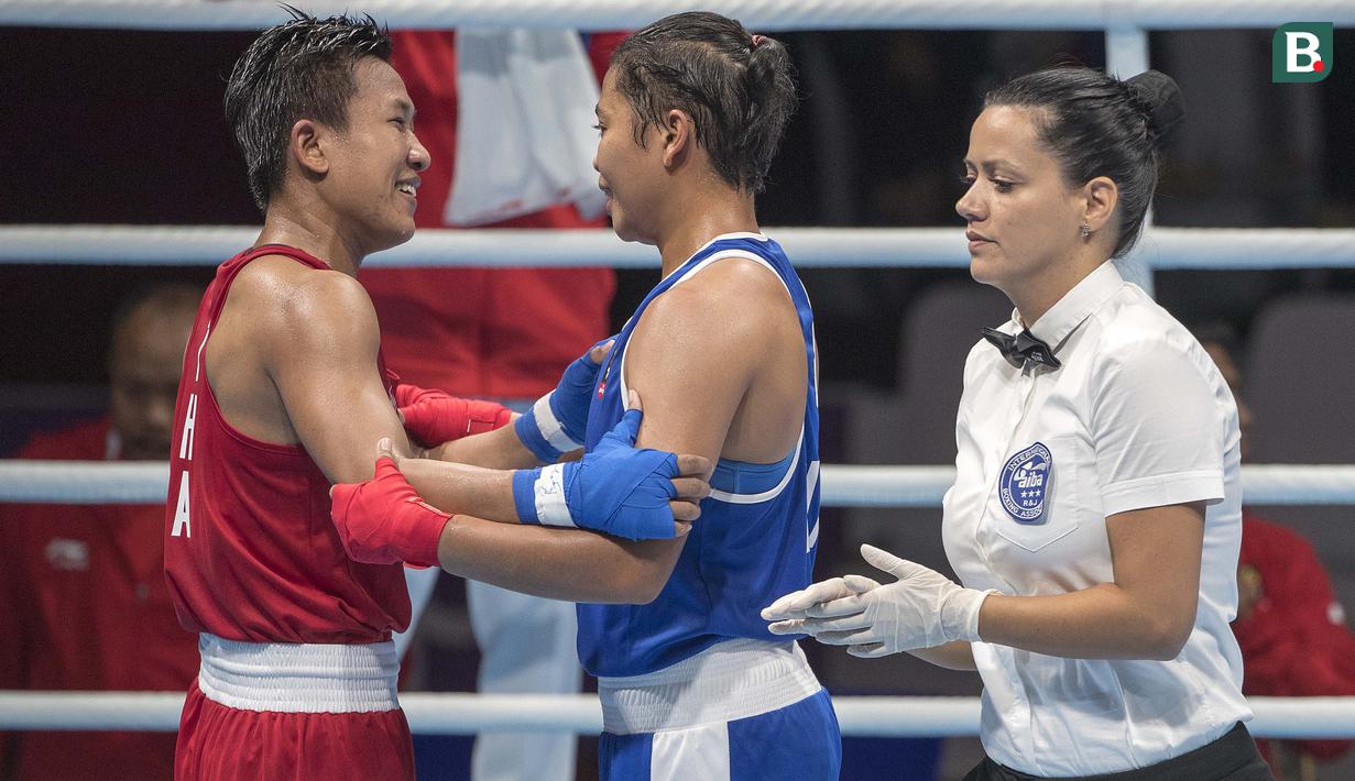 Petinju asal Indonesia Huswatun Hasanah berbincang dengan Sudaporn Seesondee asal Thailand usai babak semifinal kelas ringan (57-60 kg) Asian Games 2018 di JIExpo Kemayoran Jakarta, Jumat (31/8/2018). (Bola.com/Peksi Cahyo)