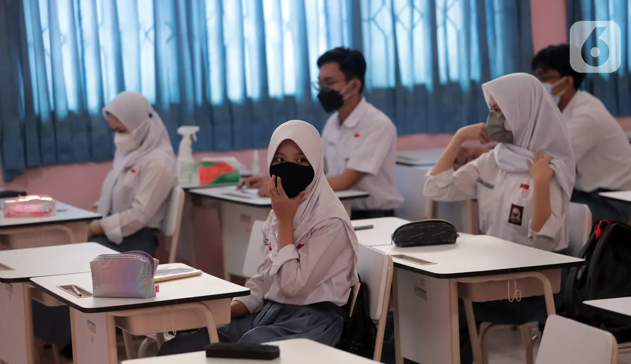 Siswa mengikuti uji coba pembelajaran tatap muka (PTM) terbatas di SMAN 1 Kota Tangerang, Banten, Senin (6/9/2021). Dinas Pendidikan Provinsi Banten uji coba PTM di SMA di Kota Tangerang secara terbatas dengan sistem bergiliran serta menerapkan protokol kesehatan ketat. (Liputan6.com/Angga Yuniar)